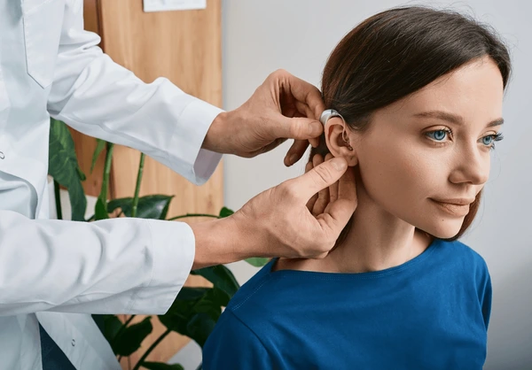 installation-hearing-aid-on-womans-600nw-2104363502